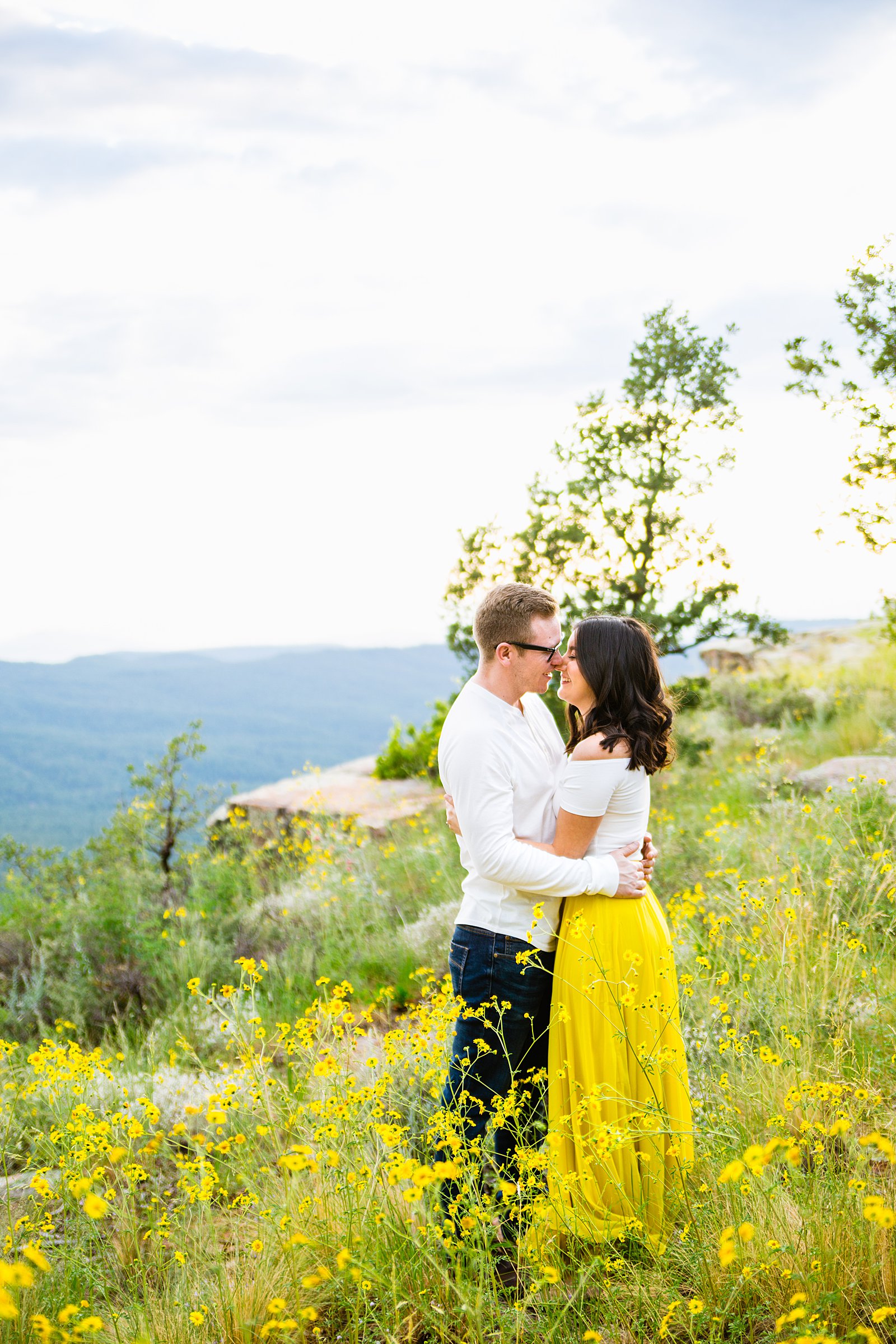Adventurous couple share an intimate moment during their Mogollon Rim engagement session by Payson engagement photographer PMA Photography.