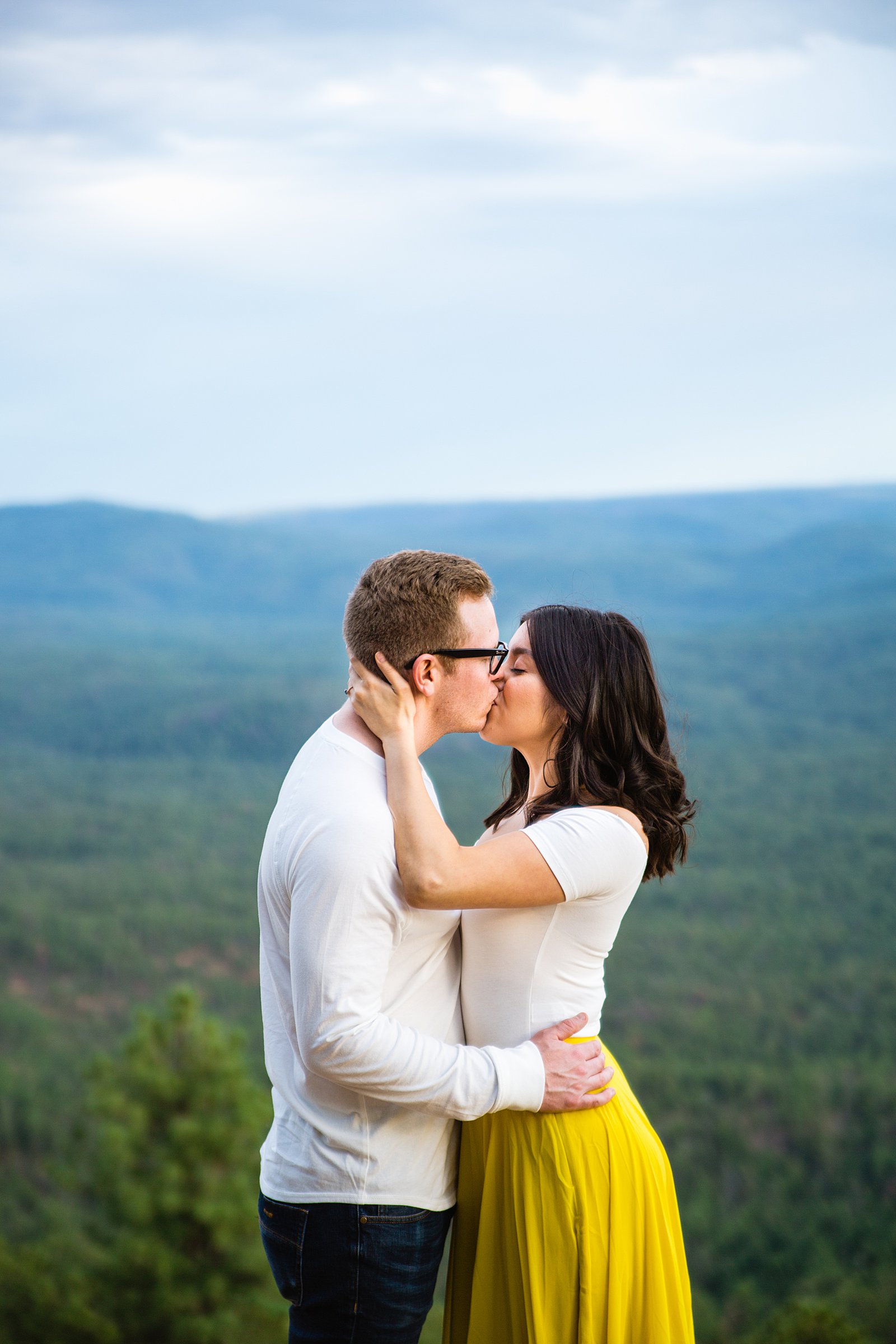 Adventurous couple share a kiss during their Mogollon Rim engagement session by Payson wedding photographer PMA Photography.