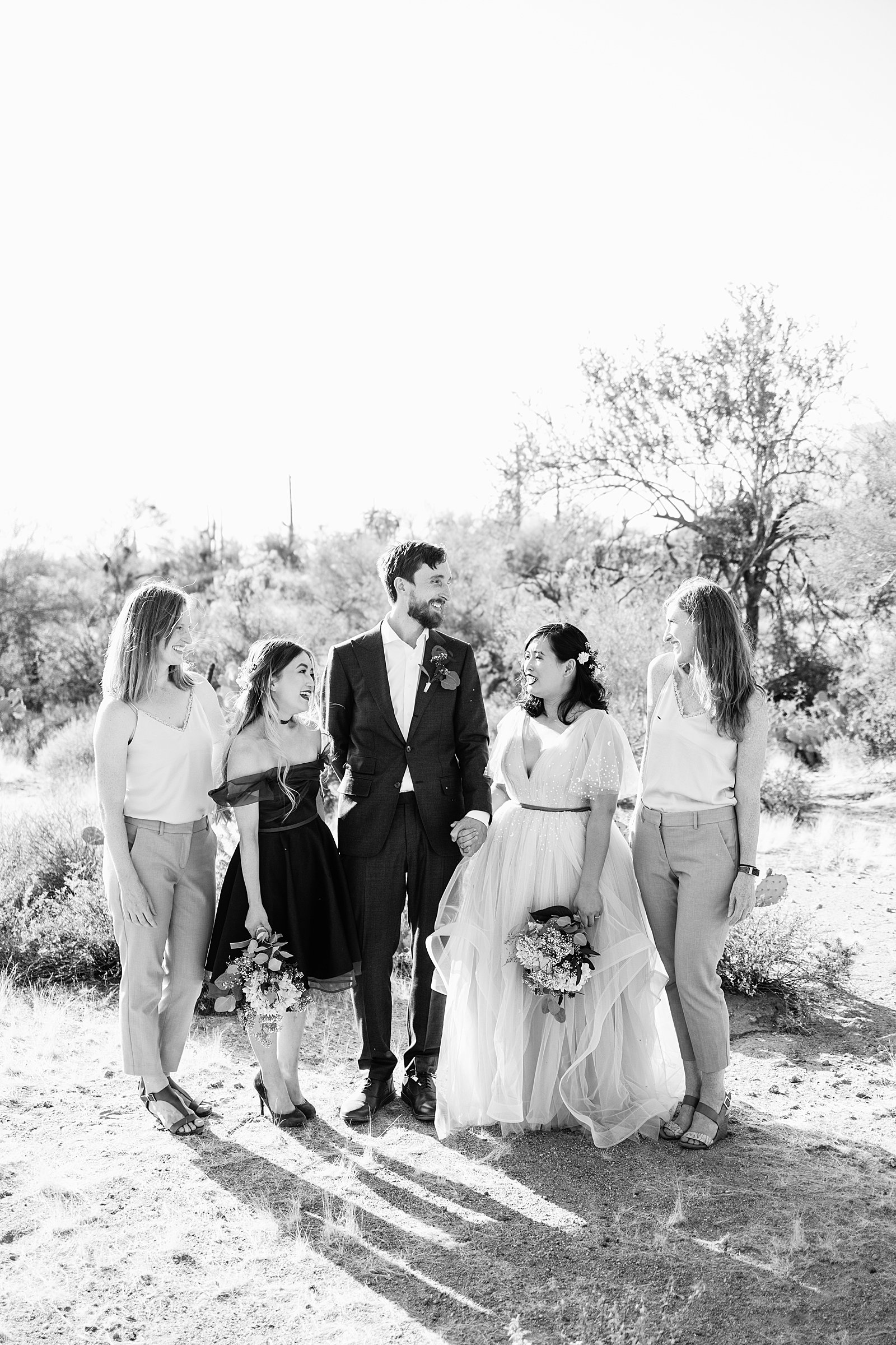 Mixed gender bridal party laughing together at Cloth and Flame Superstition Mountain wedding by Mesa wedding photographer PMA Photography.