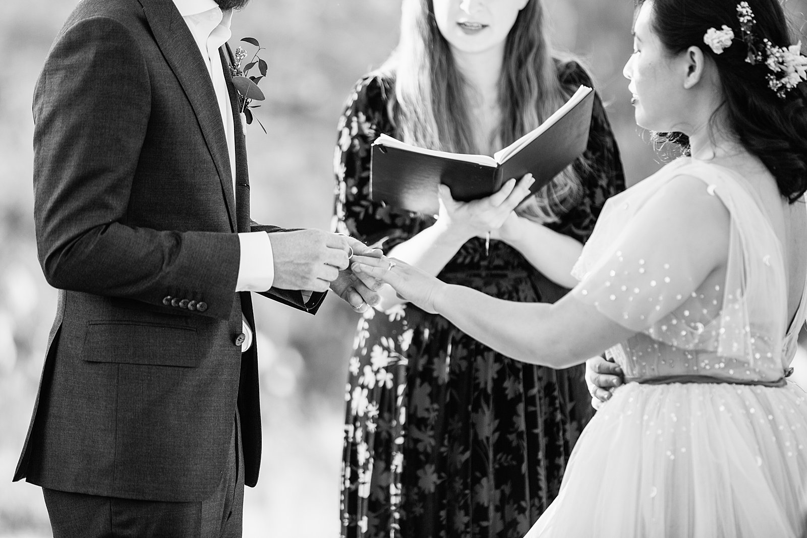Bride and Groom exchange rings during their wedding ceremony at the Superstition Mountains by Phoenix wedding photographer PMA Photography.