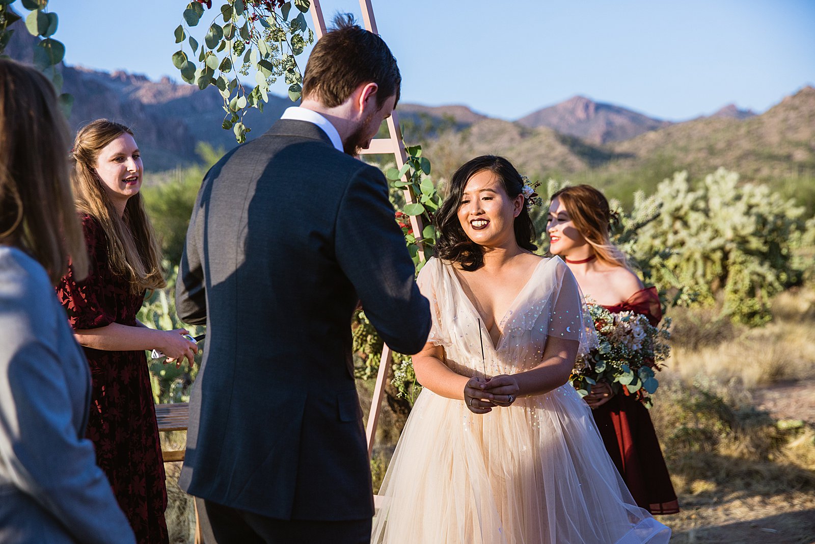 Bride and Groom light a sparkler for their unity ceremony during their wedding ceremony at the Superstition Mountains by Arizona wedding photographer PMA Photography.