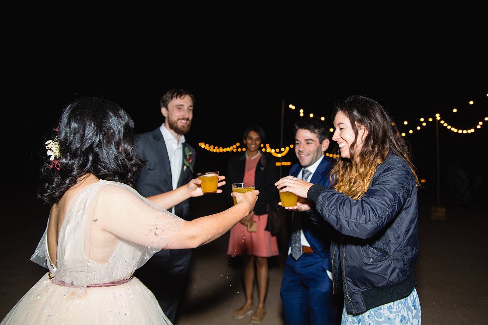 Bride handing out custom drinks to their guests at a Cloth and Flame wedding by PMA Photography.