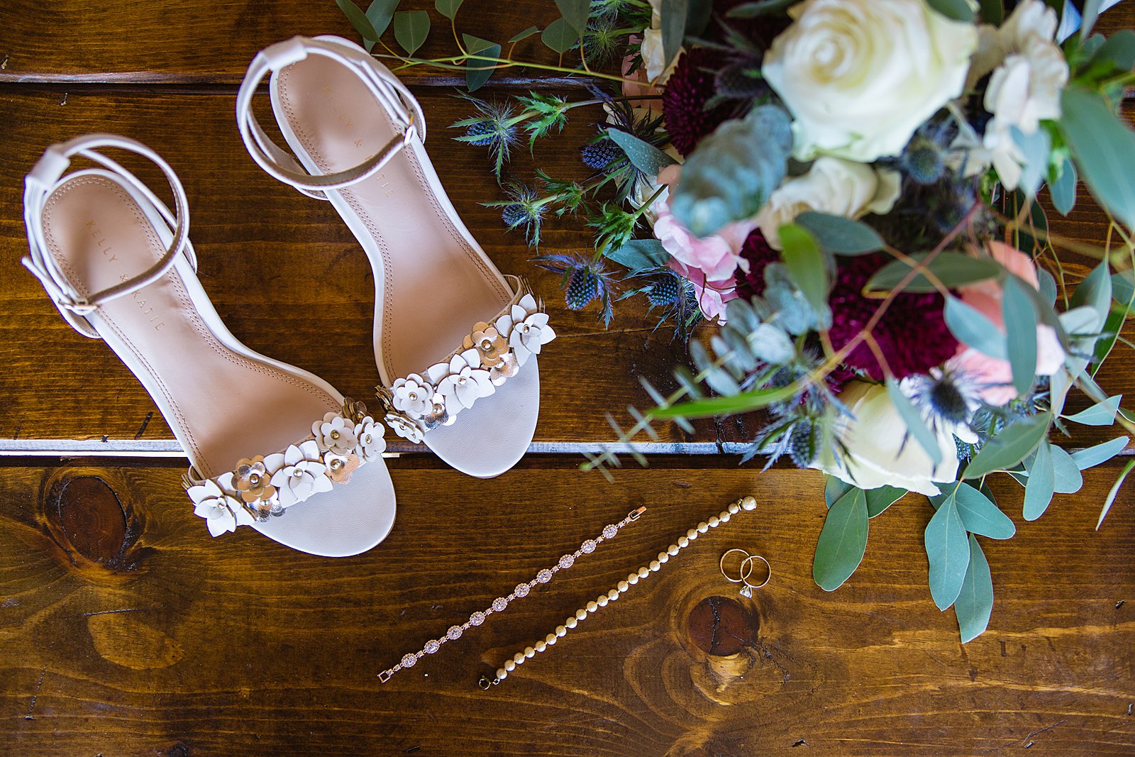 Brides's wedding day details of floral shoes, romantic bouquet, and jewelry by PMA Photography.