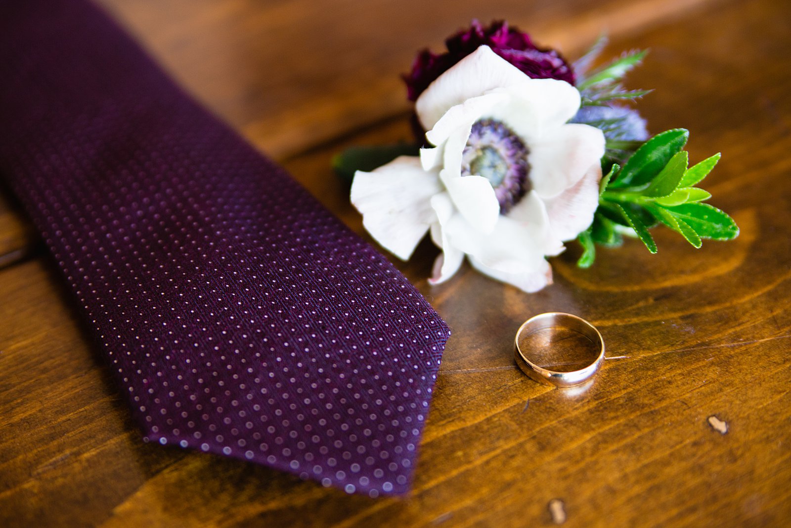 Groom's wedding day details of his ring, tie, and boutonniere by PMA Photography.