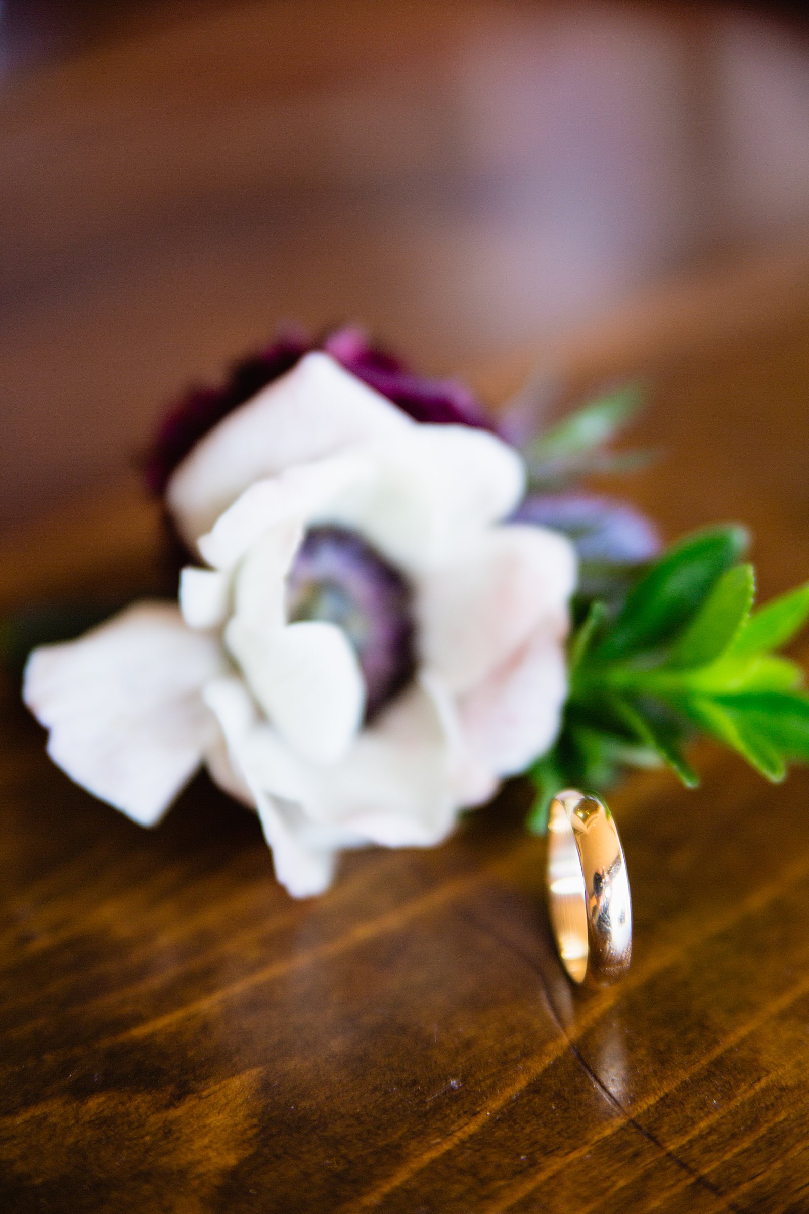 Groom's simple gold wedding ring and romantic butonniere by PMA Photography.