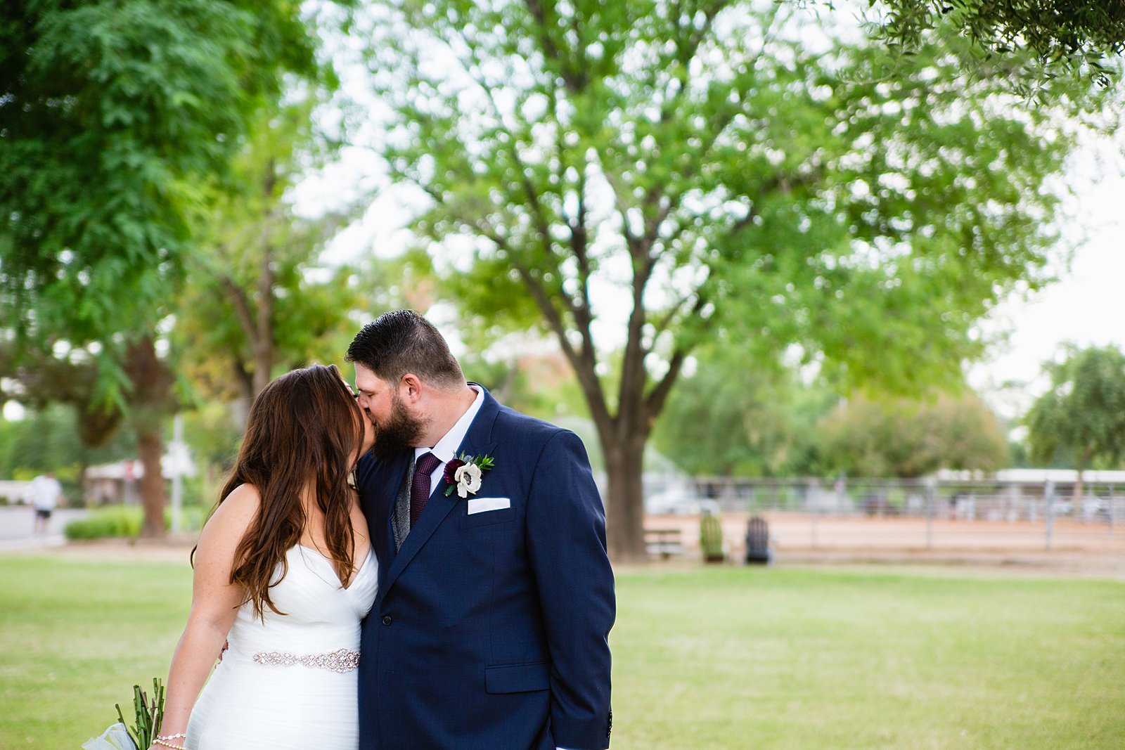 Bride and Groom share a kiss during their Arizona backyard wedding by Arizona wedding photographer PMA Photography.