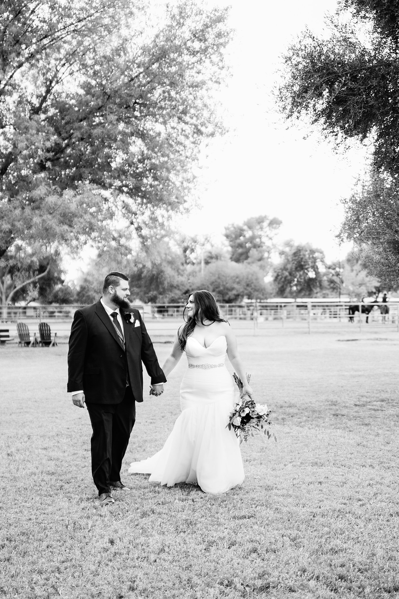 Bride and Groom walking together during their Arizona backyard wedding by Arizona wedding photographer PMA Photography.
