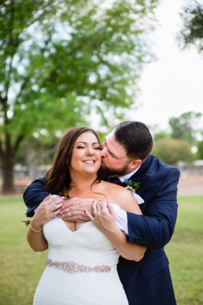 Bride and Groom laughing together during their Arizona backyard wedding by Tempe wedding photographer PMA Photography.