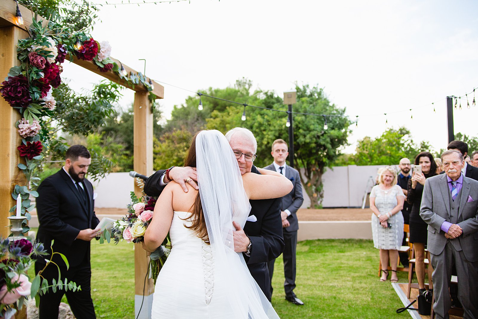 Bride walking down aisle during an Arizona backyard wedding ceremony by Phoenix wedding photographer PMA Photography.