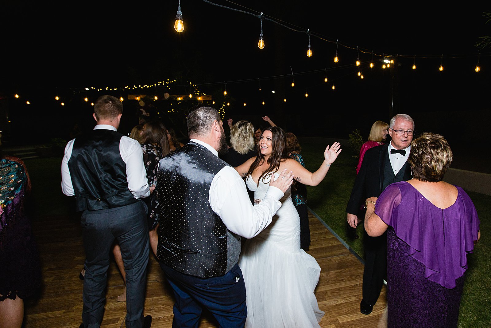 Bride and Groom dancing with guests at their arizona backyard wedding wedding reception by Arizona wedding photographer PMA Photography