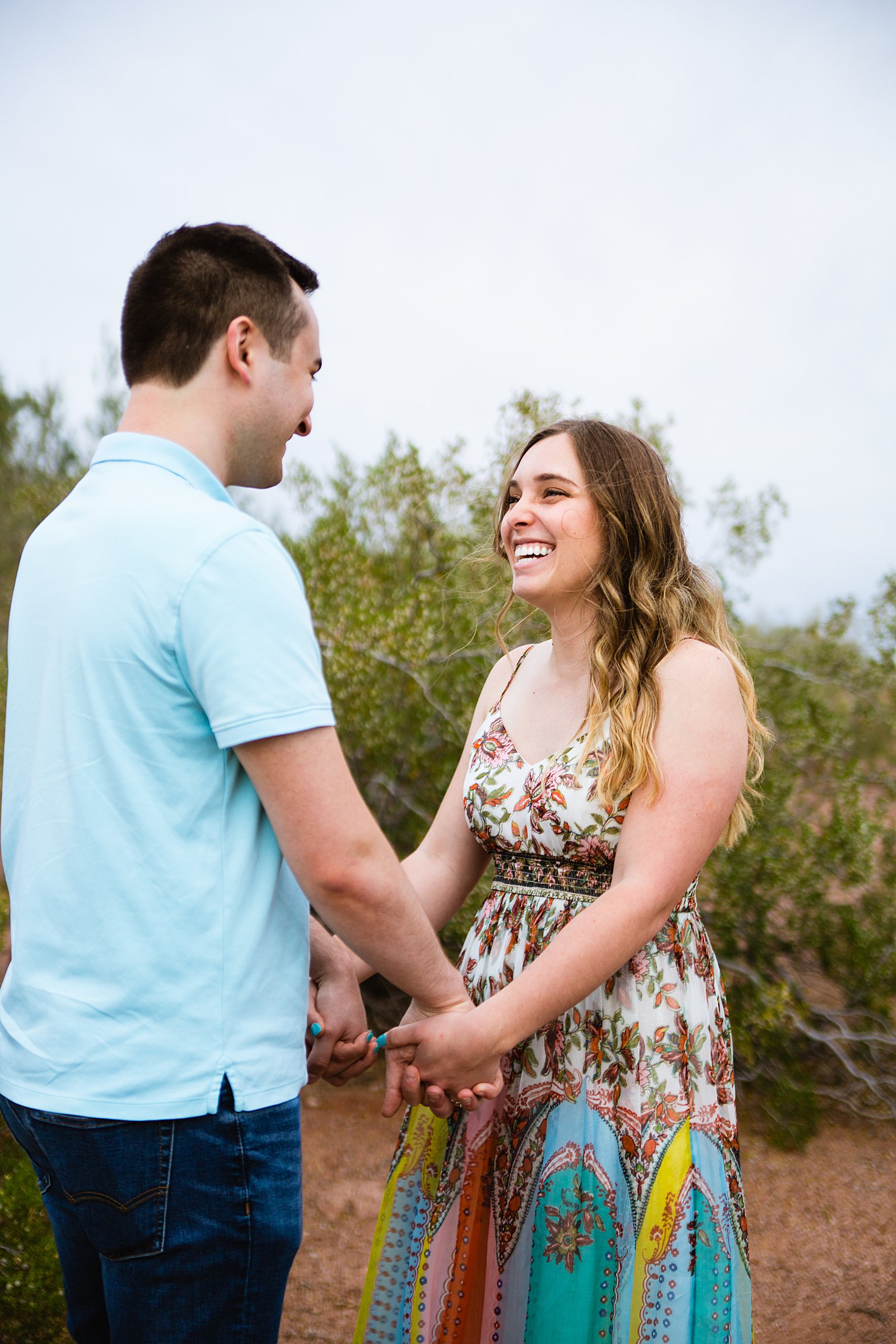 Couple laugh together during their Phoenix engagement session by Arizona engagement photographer PMA Photography.