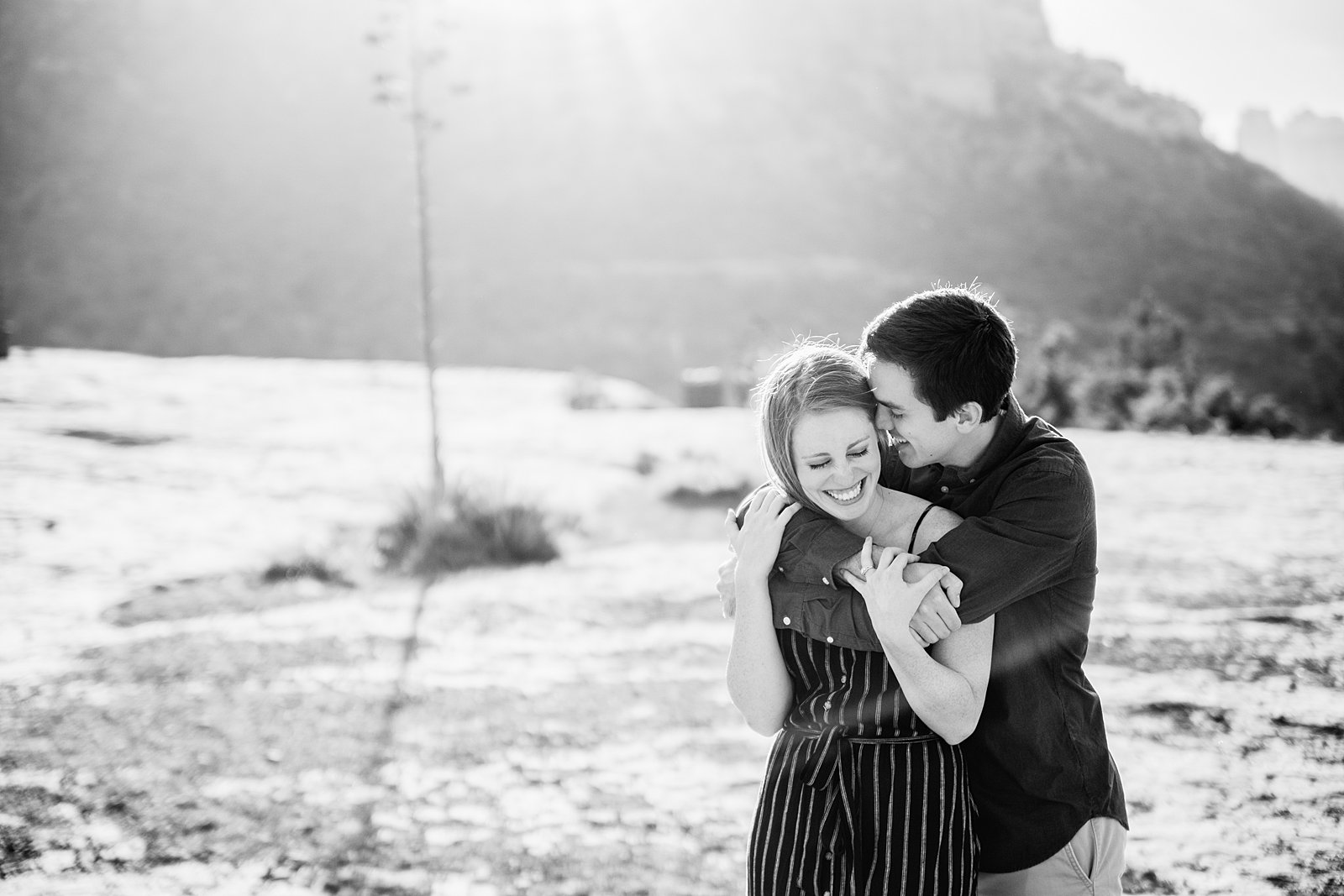 Couple laugh together during their Bell Rock engagement session by Sedona engagement photographer PMA Photography.