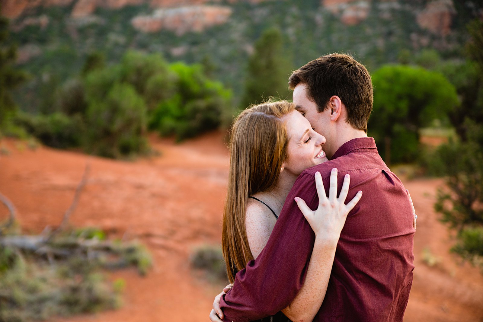 Couple share an intimate moment during their Bell Rock engagement session by Sedona engagement photographer PMA Photography.