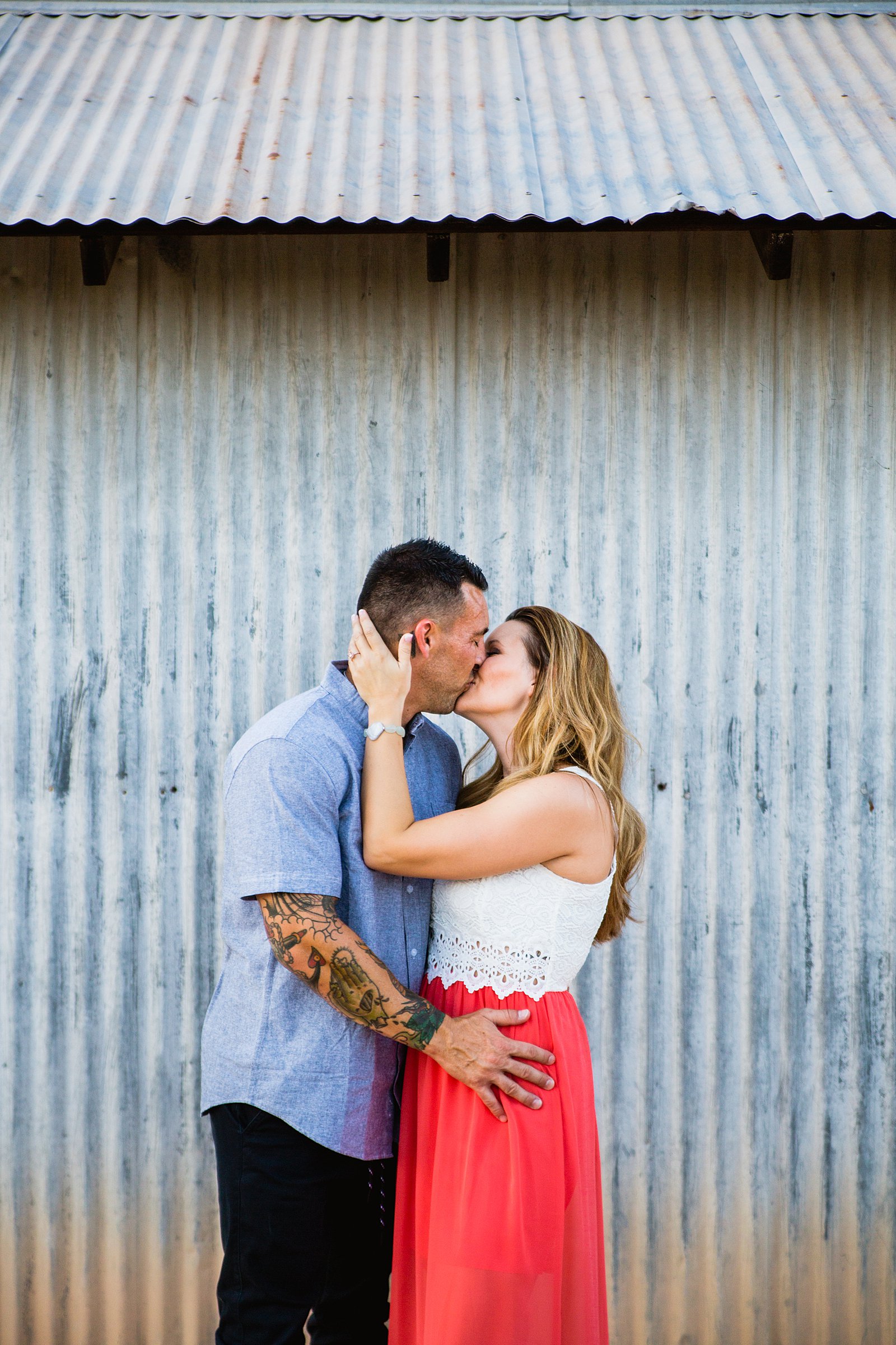 Couple share a kiss during their Chandler engagement session by Arizona wedding photographer PMA Photography.