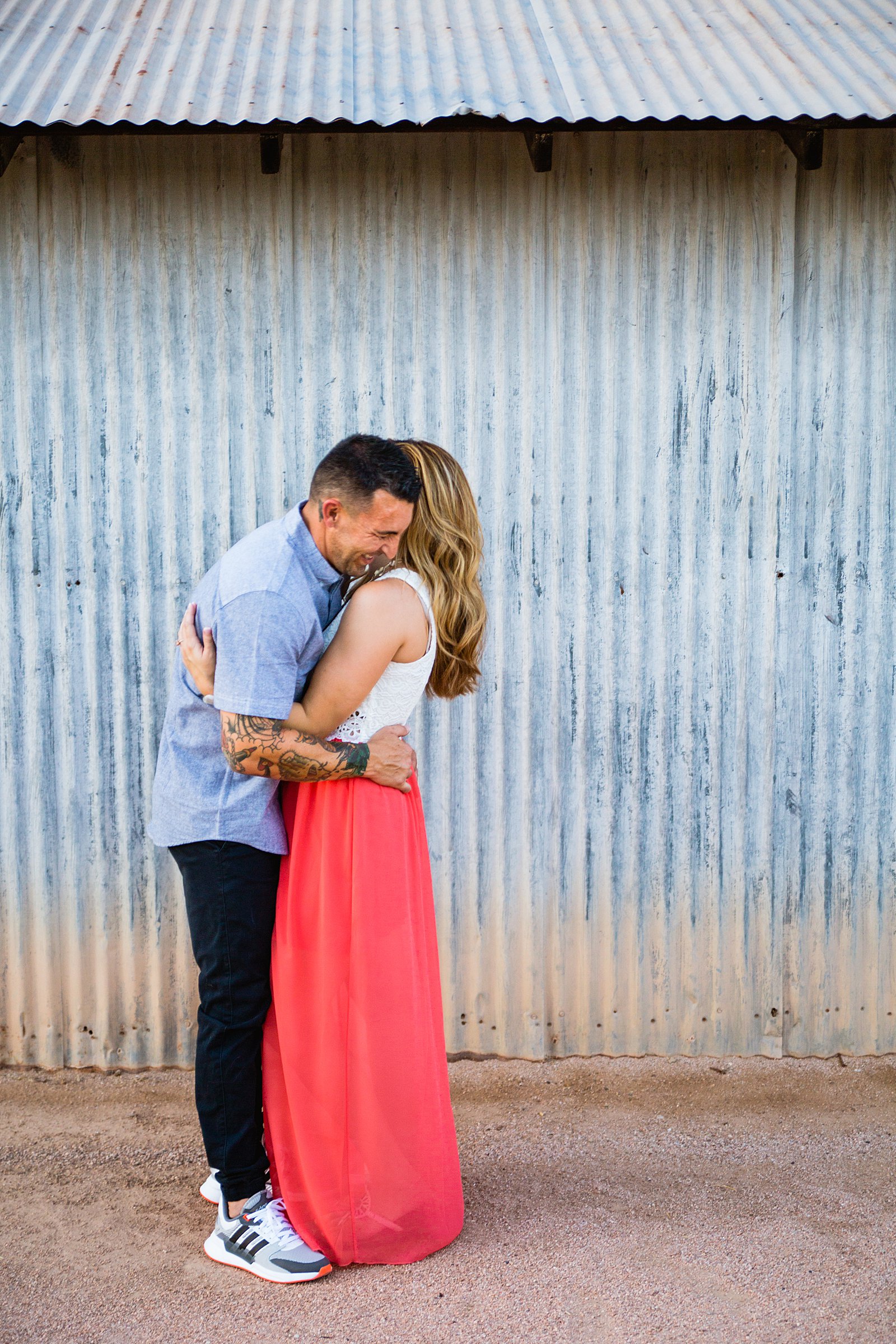 Couple laugh together during their Chandler engagement session by Arizona engagement photographer PMA Photography.