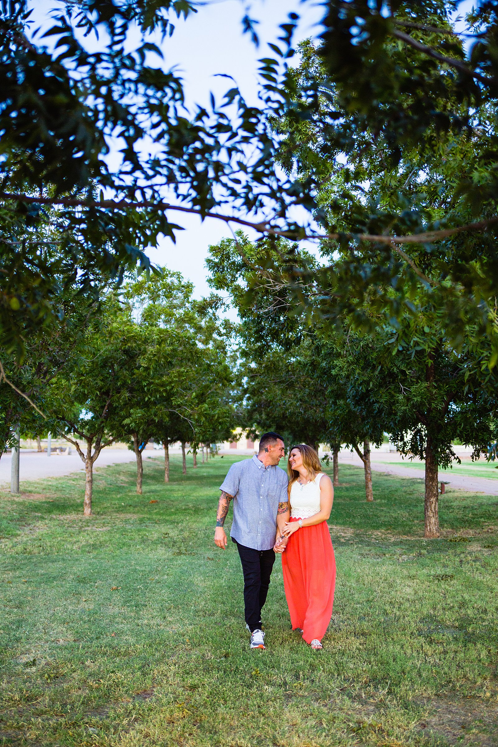 Couple walking together during their Chandler engagement session by Arizona engagement photographer PMA Photography.