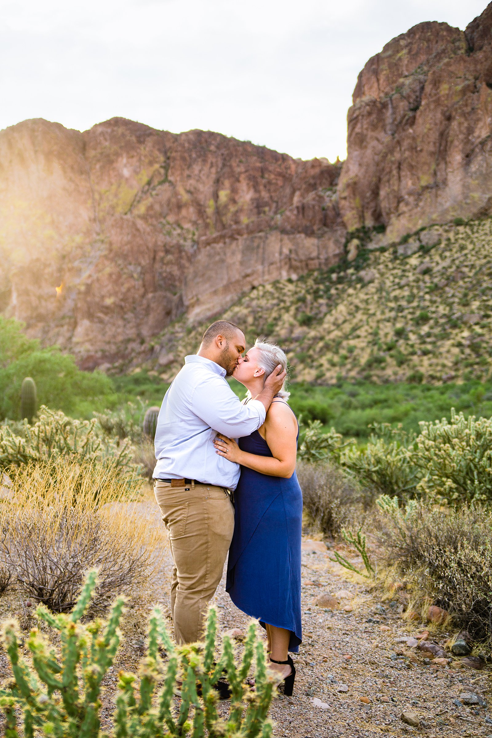 Adventurous couple share a kiss during their Phoenix engagement session by Arizona wedding photographer PMA Photography.