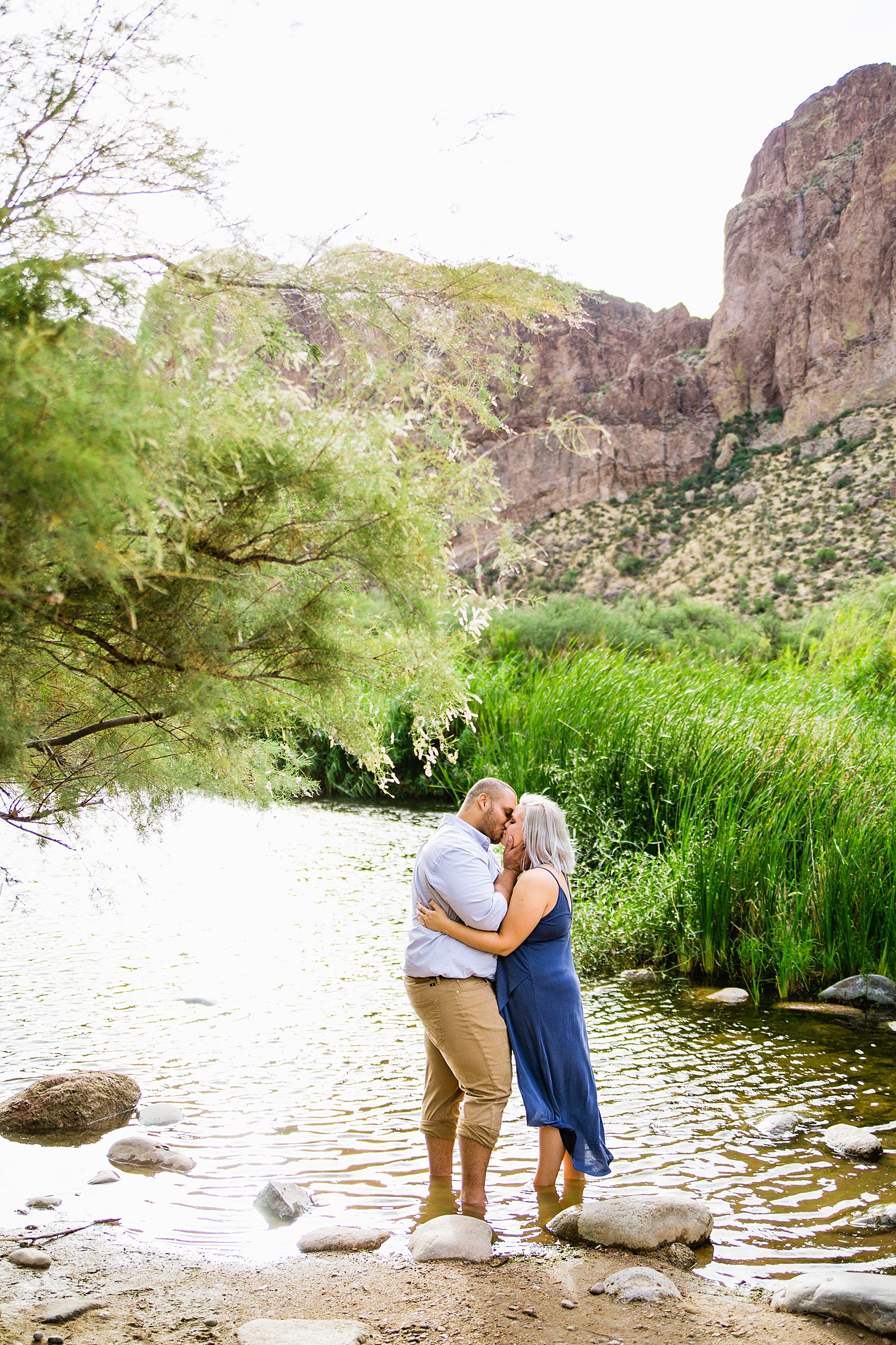 Adventurous couple share a kiss during their Salt River engagement session by Phoenix wedding photographer PMA Photography.