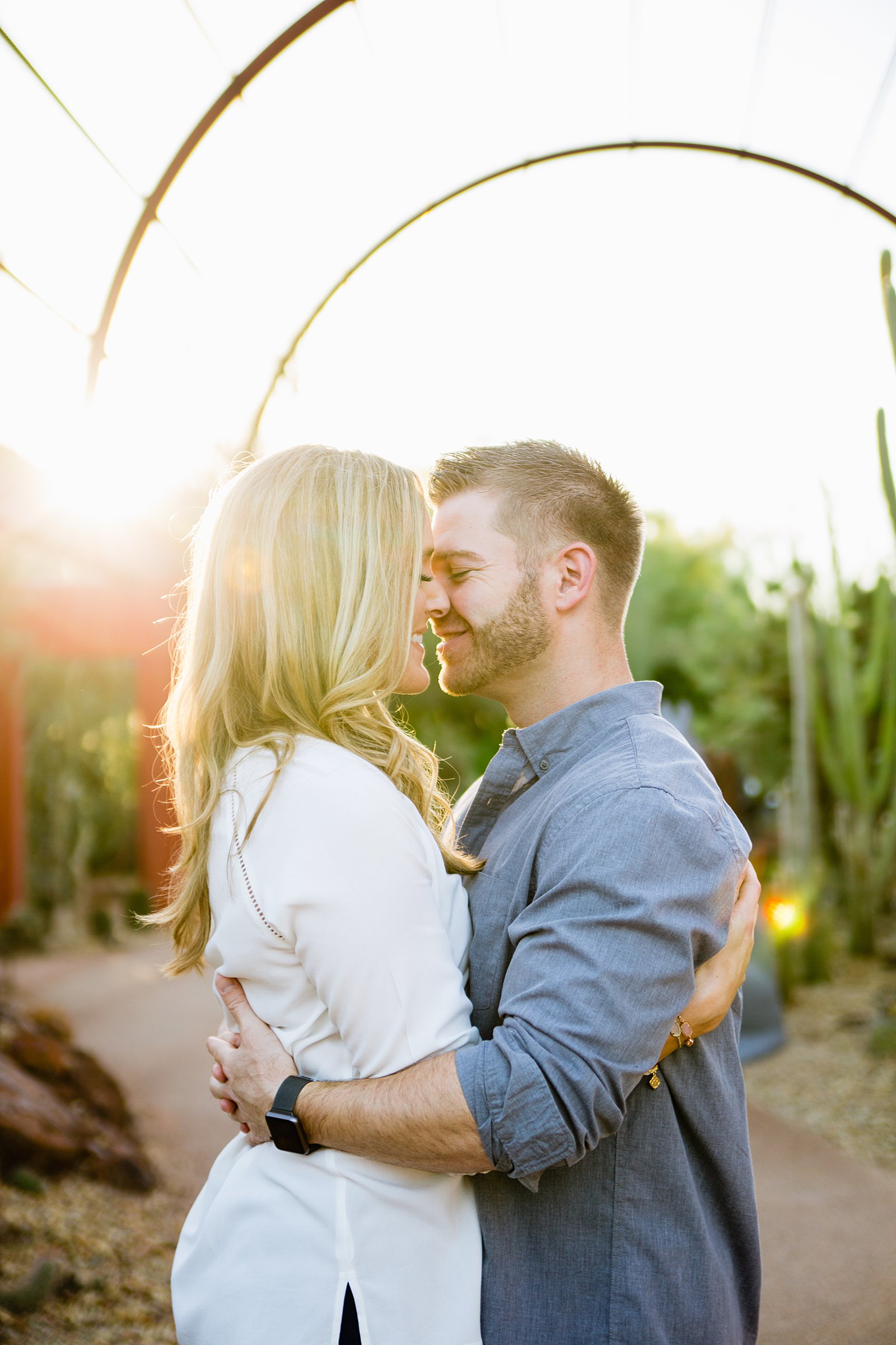 Couple share an intimate moment during their Desert Botanical Gardens engagement session by Phoenix engagement photographer PMA Photography.