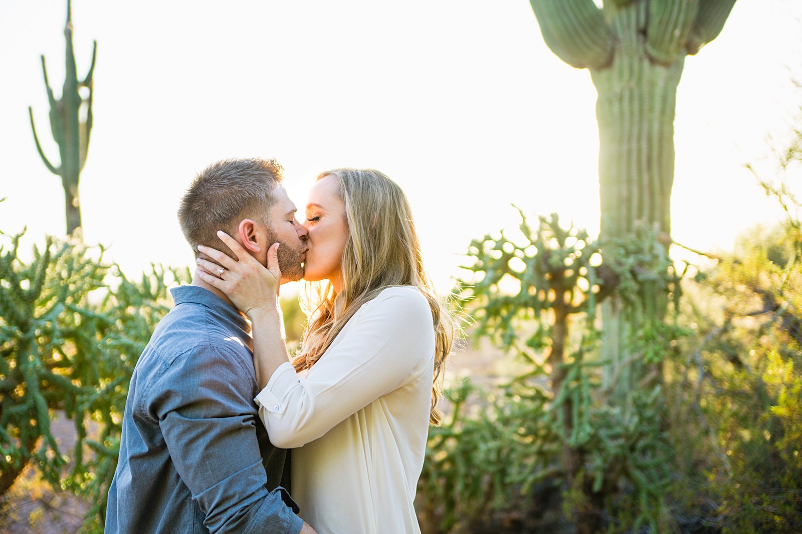 Couple share a kiss during their Desert Botanical Gardens engagement session by Phoenix wedding photographer PMA Photography.