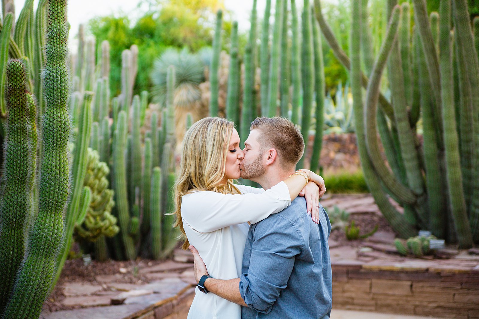 Couple share a kiss during their Desert Botanical Gardens engagement session by Phoenix wedding photographer PMA Photography.