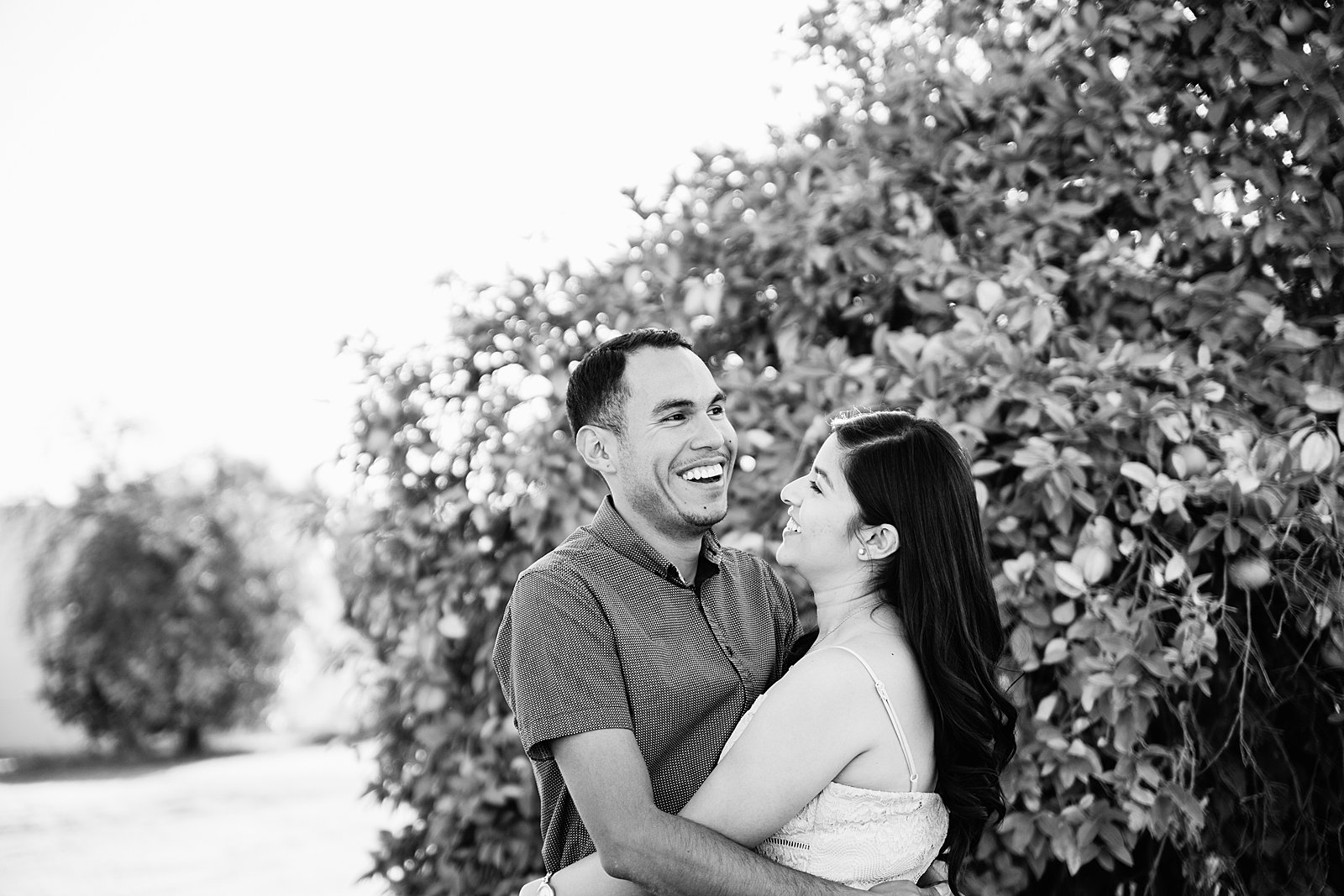 Couple laugh together during their Glendale engagement session by Arizona engagement photographer PMA Photography.