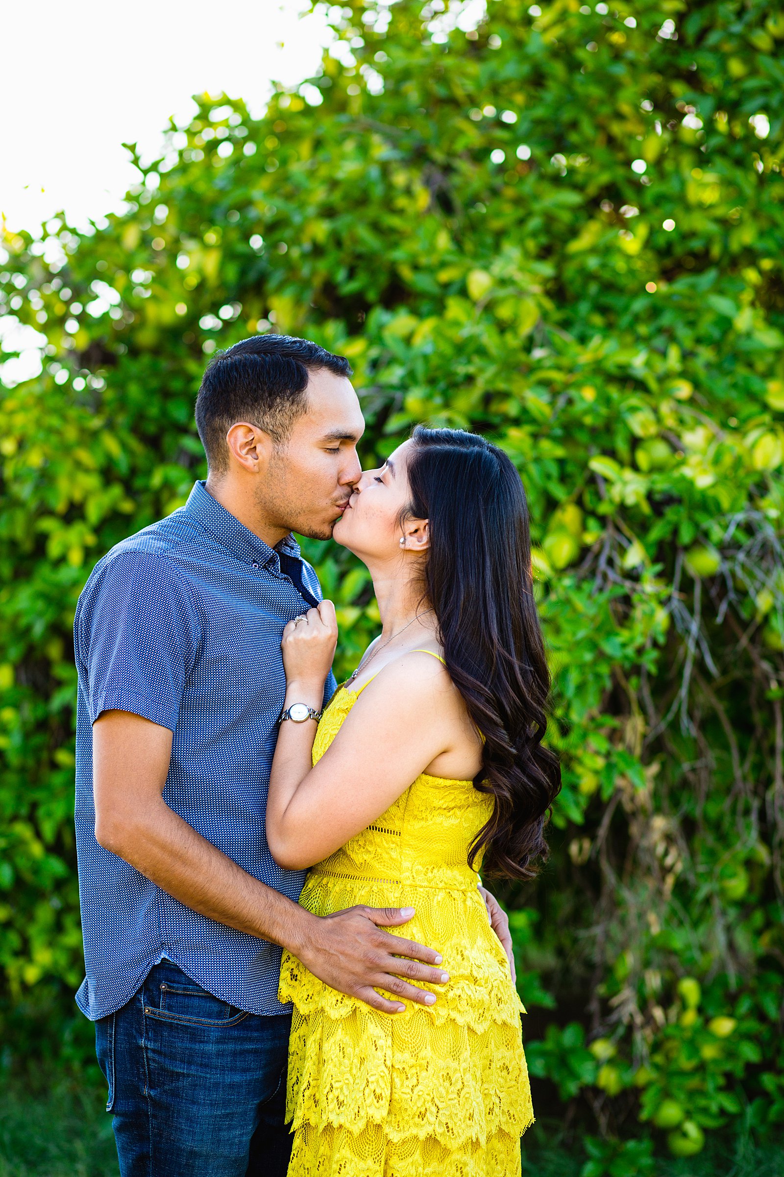 Couple share a kiss during their Sahuaro Ranch engagement session by Glendale wedding photographer PMA Photography.