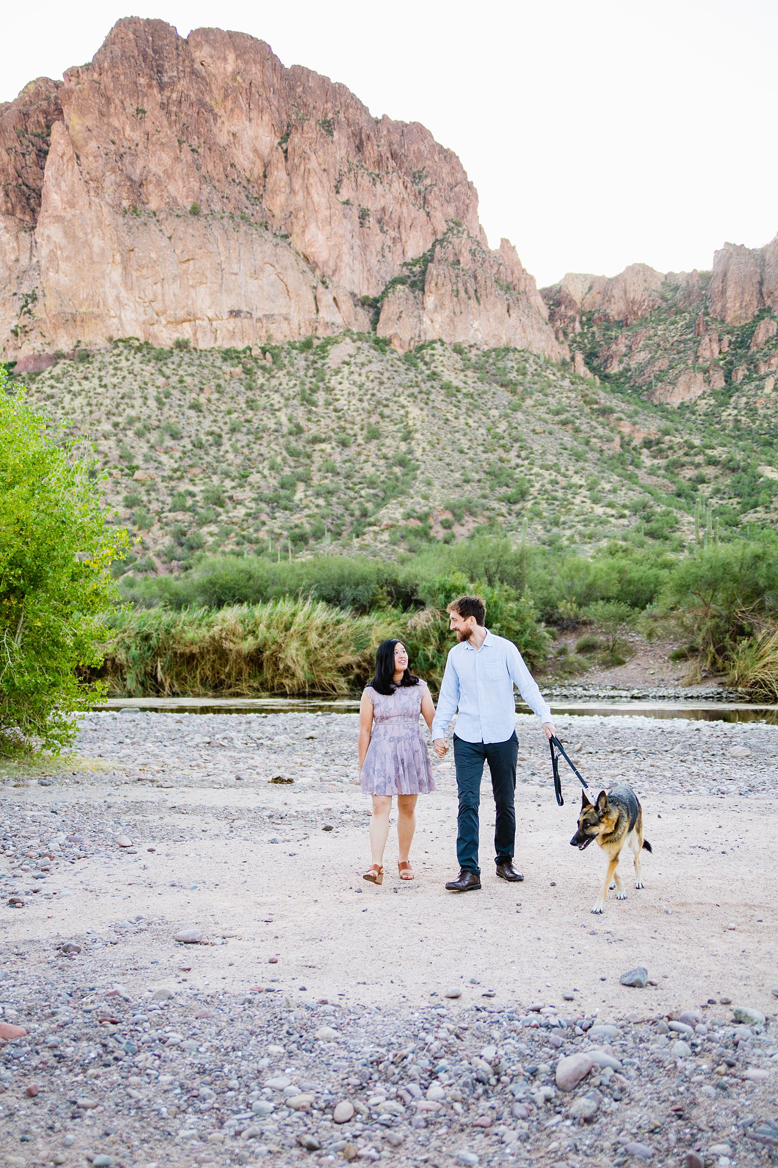 Couple walking together with their dog during their Salt River engagement session by Phoenix engagement photographer PMA Photography.