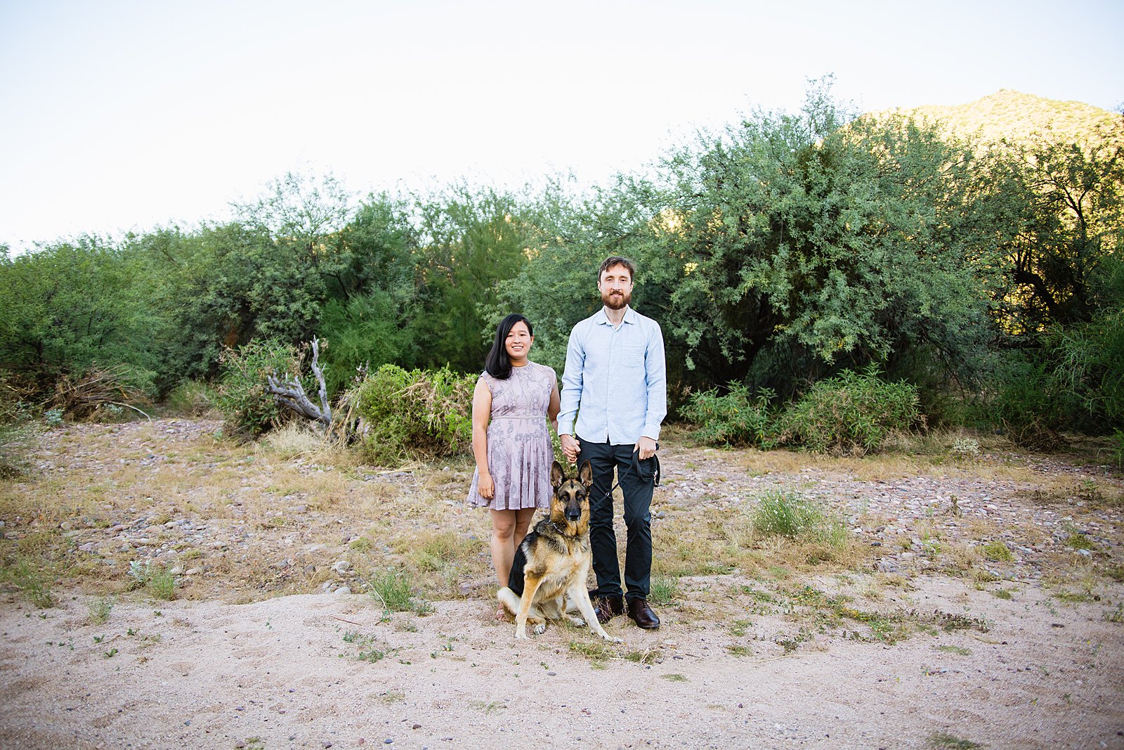 Couple pose with their dog during their Phoenix engagement session by Arizona wedding photographer PMA Photography.