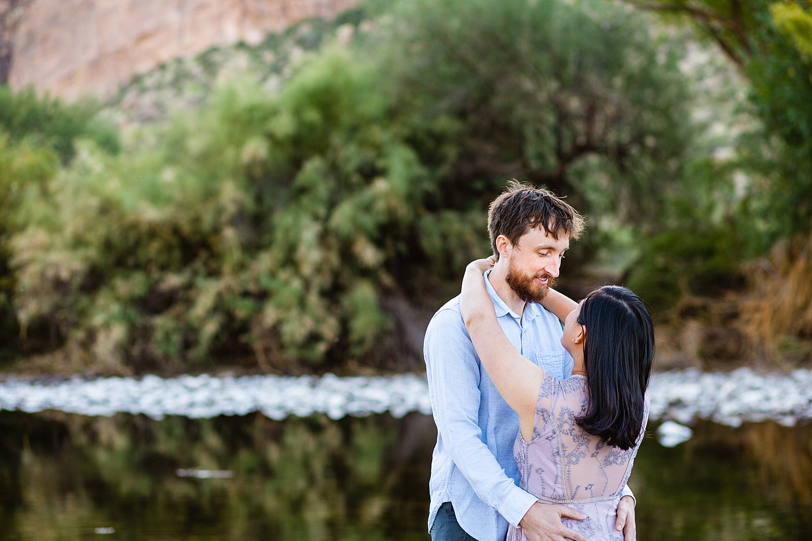 Couple look at each other during their Salt River engagement session by Phoenix wedding photographer PMA Photography.