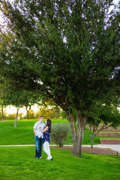 Couple look at each other during their Anthem Park engagement session by Phoenix wedding photographer PMA Photography.
