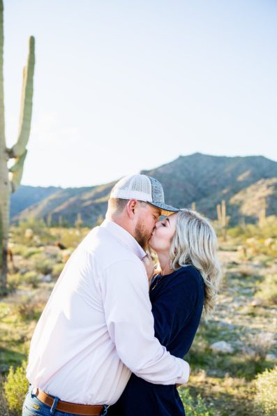 Couple share a kiss during their White Tanks engagement session by Phoenix wedding photographer PMA Photography.