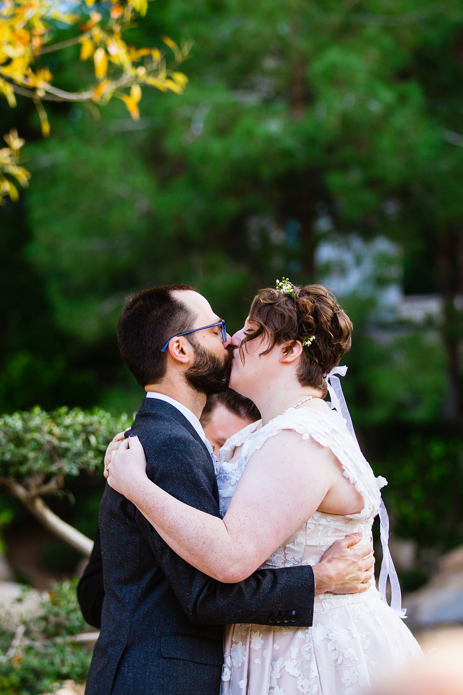 Bride and Groom share their first kiss during their wedding ceremony at Japanese Friendship Garden by Arizona wedding photographer PMA Photography.