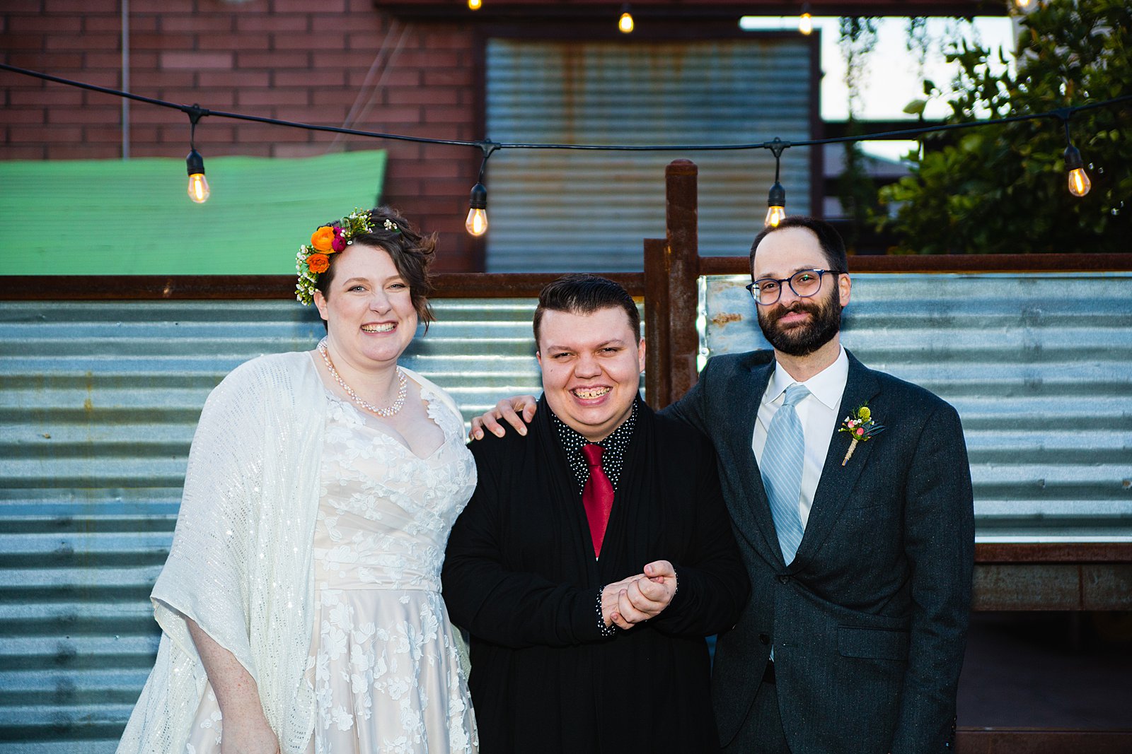 Bride and groom with their officiant at The Duce wedding reception by Arizona wedding photographer PMA Photography.