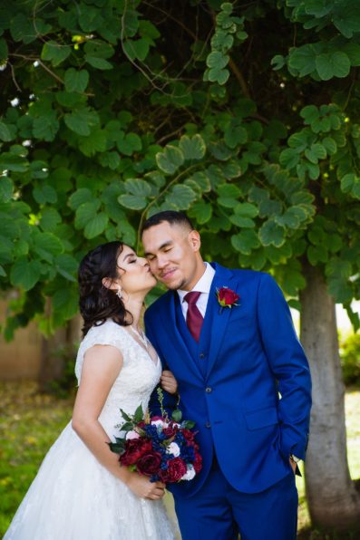 Bride and Groom share a kiss during their Valley Garden Center wedding by Arizona wedding photographer PMA Photography.