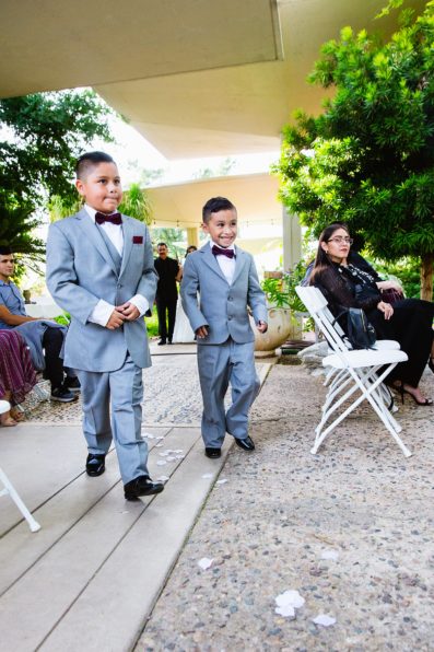 Ring bearers walking down aisle during Valley Garden Center wedding ceremony by Phoenix wedding photographer PMA Photography.