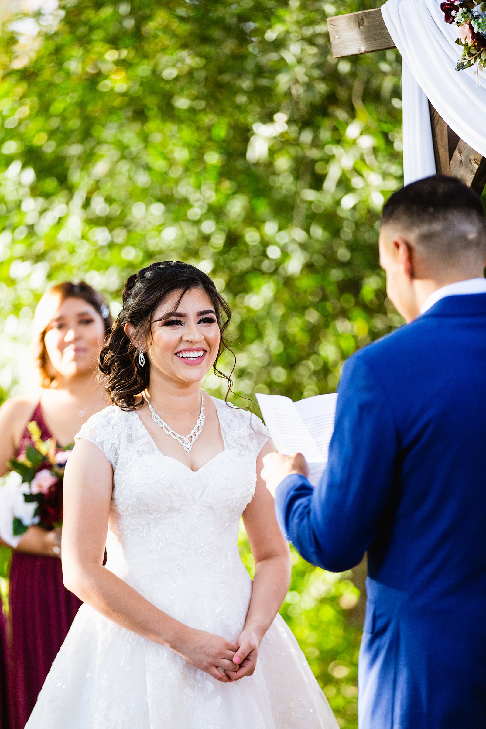 Bride looking at her groom during their wedding ceremony at Valley Garden Center by Phoenix wedding photographer PMA Photography.