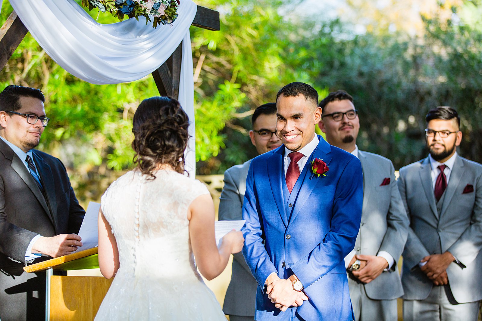 Groom looking at his bride during their wedding ceremony at Valley Garden Center by Phoenix wedding photographer PMA Photography.
