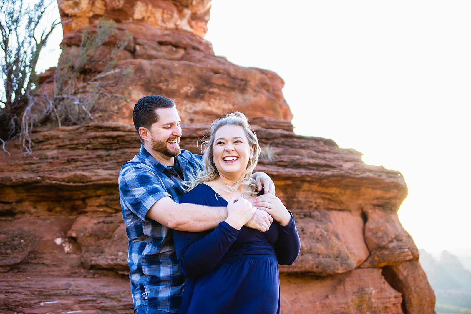 Adventurous couple laugh together during their Sedona engagement session by Arizona engagement photographer PMA Photography.