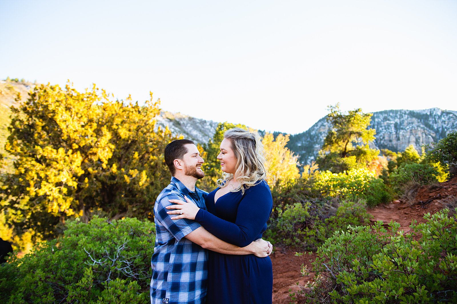 Adventurous look at each other during their Sedona engagement session by Arizona wedding photographer PMA Photography.