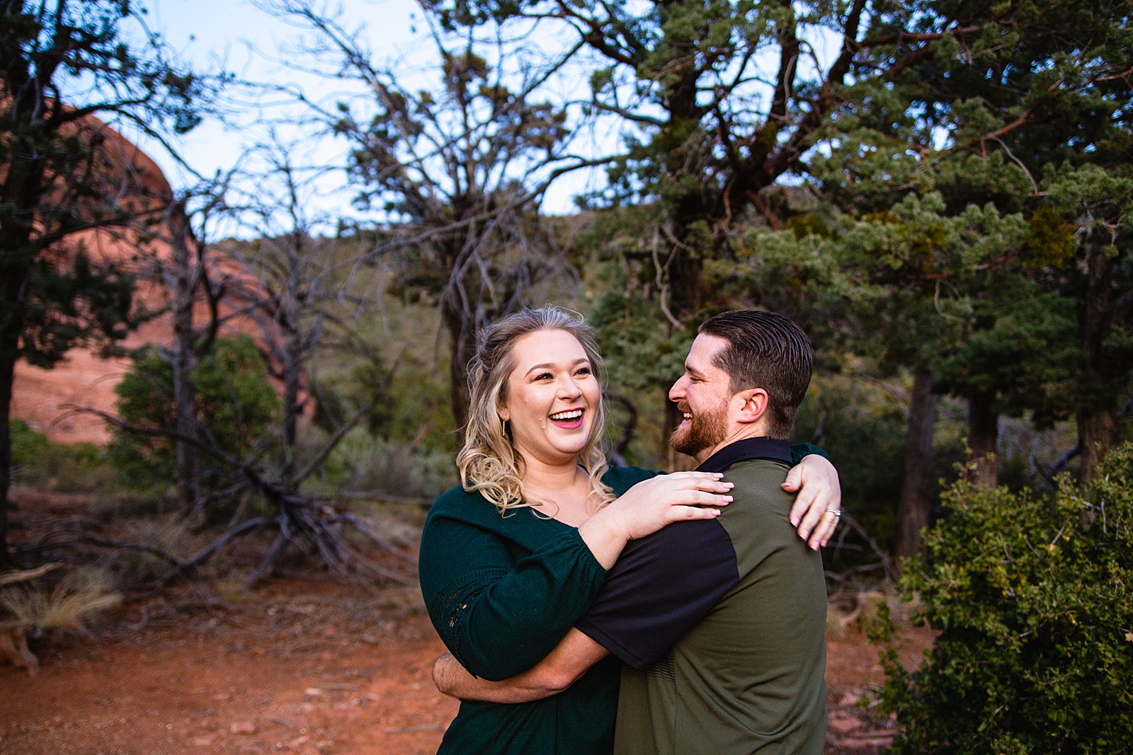 Couple laugh together during their Merry Go Round Rock engagement session by Sedona engagement photographer PMA Photography.
