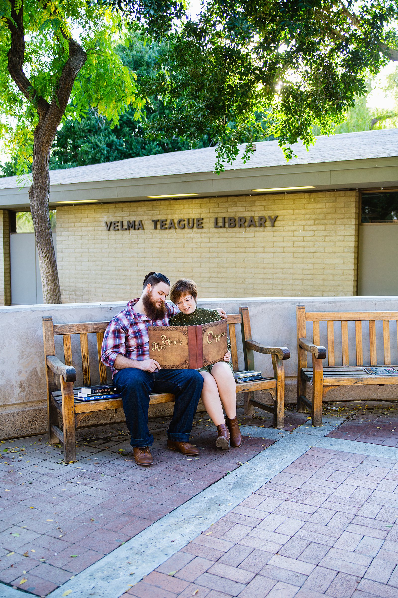 Couple reading a fairy tale together during their Downtown Glendale engagement session by Glendale engagement photographer PMA Photography.