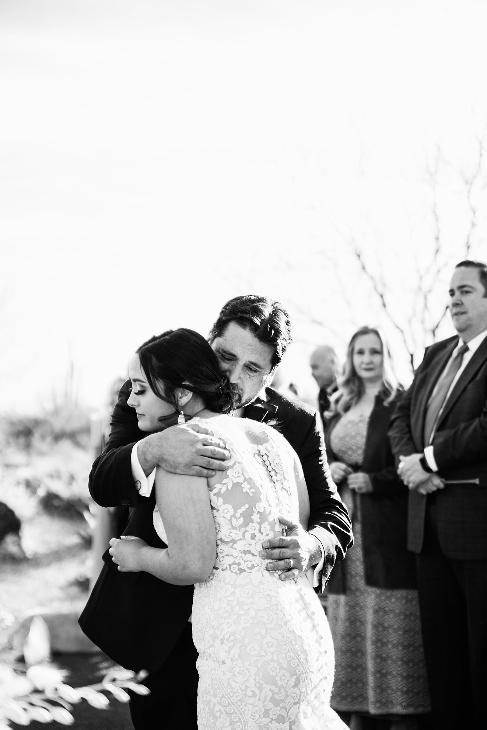 Bride and her father hugging during a wedding ceremony at The Paseo wedding venue by PMA Photography.