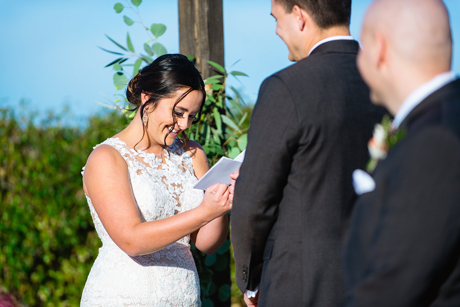Bride laughing with her groom during their wedding ceremony at The Paseo by Apache Junction wedding photographer PMA Photography.