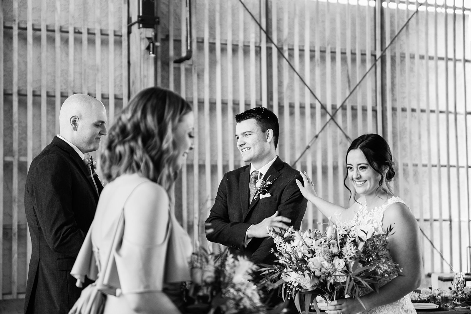 Bride and groom share a candid moment with guests just after their ceremony by PMA Photography.