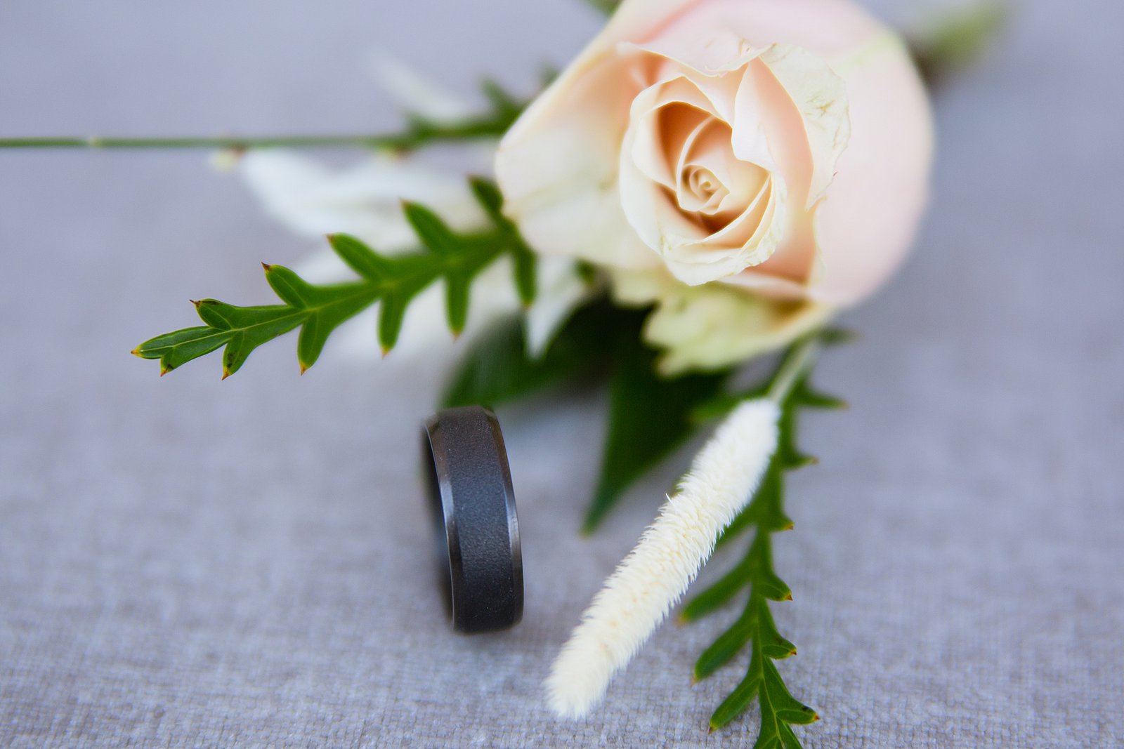 Groom's unique black wedding band and wild rose boutonniere wedding day details by PMA Photography.