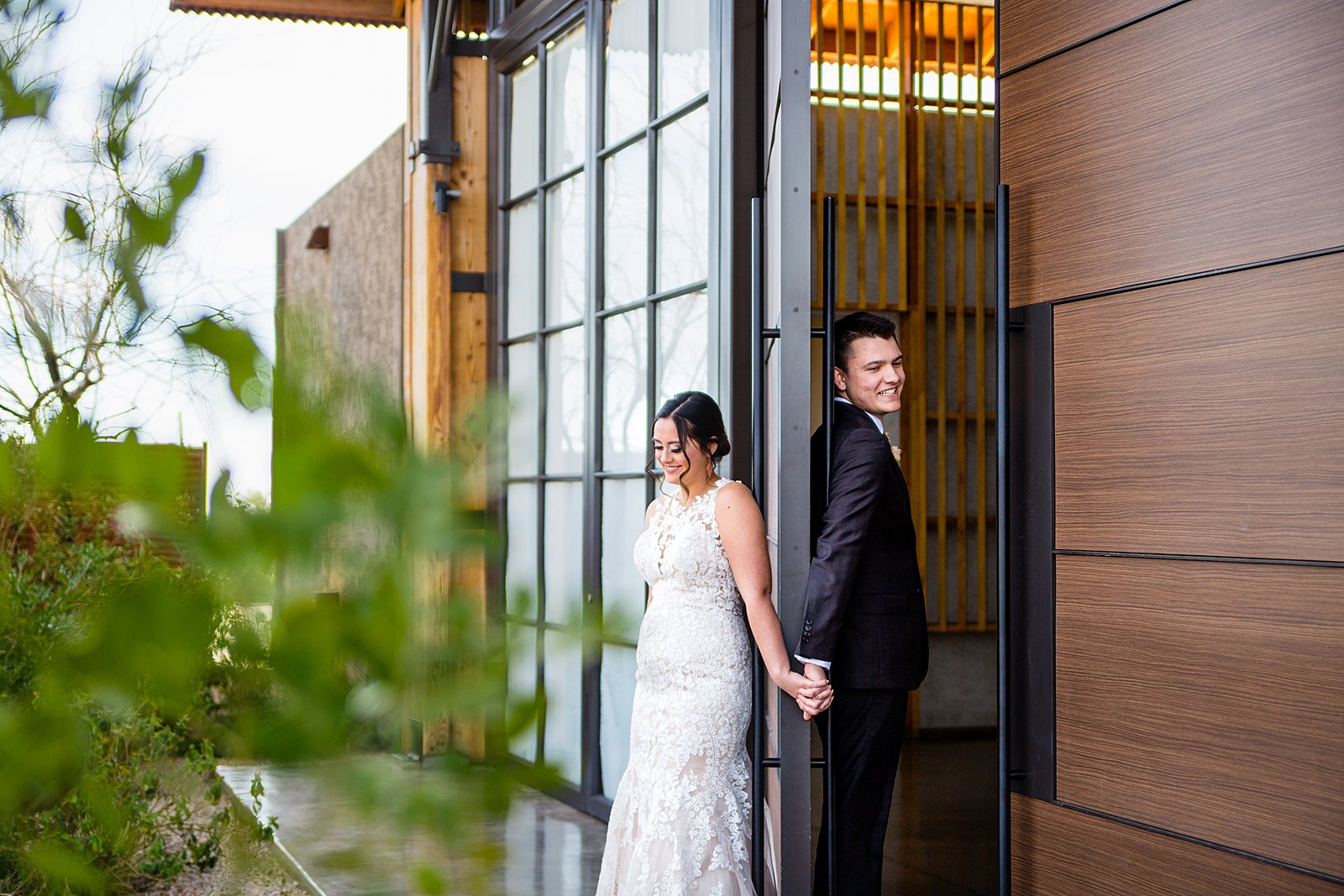 Bride and groom share a first touch during their The Paseo wedding by Arizona wedding photographers PMA Photography.