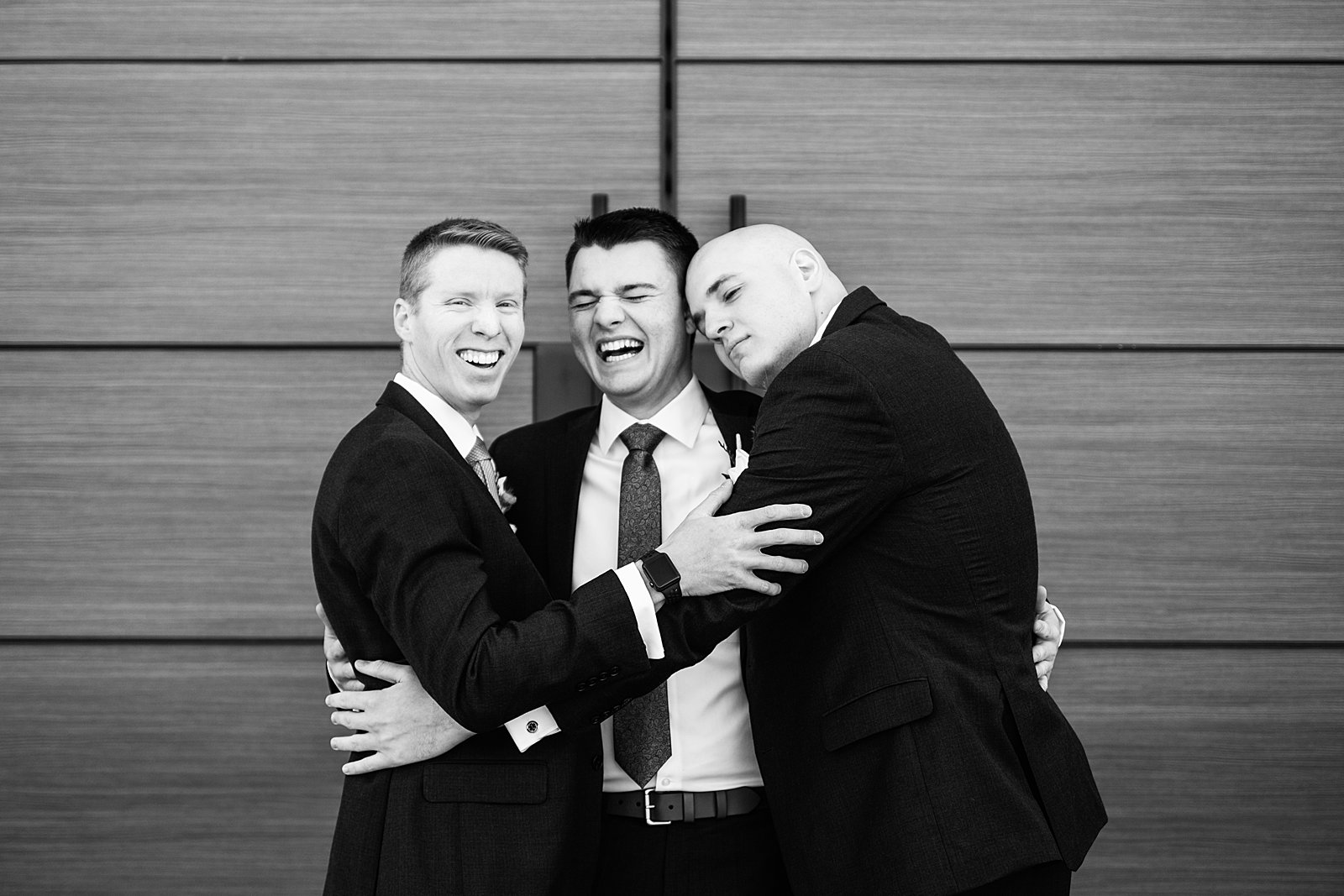Groom and groomsmen laughing together at The Paseo wedding by Apache Junction wedding photographer PMA Photography.