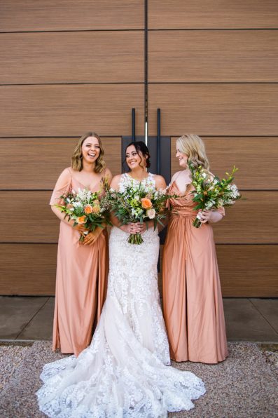 Bride and bridesmaids laughing together at The Paseo wedding by Apache Junction wedding photographer PMA Photography.
