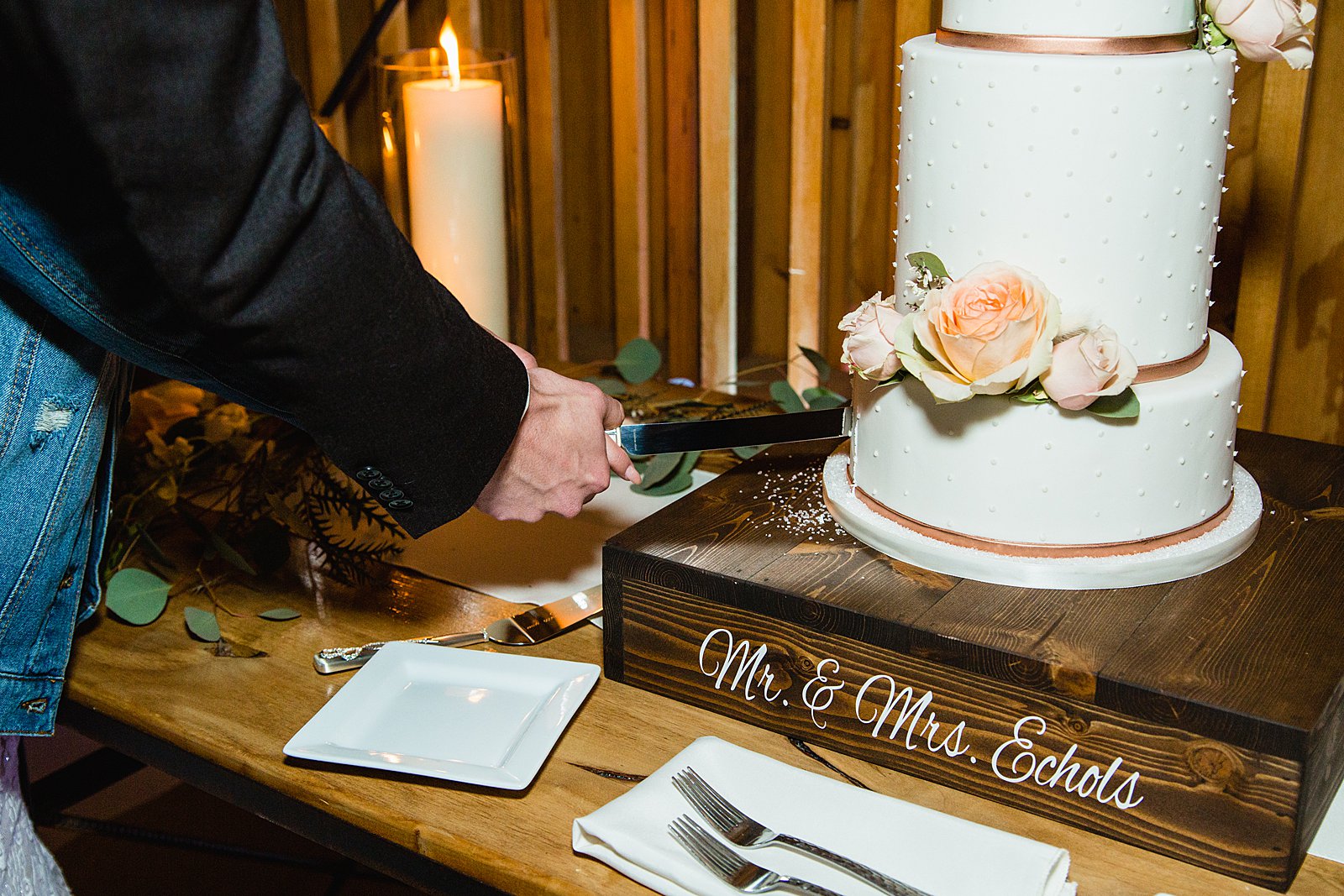 Bride and Groom cutting their wedding cake at their The Paseo wedding reception by Arizona wedding photographer PMA Photography.